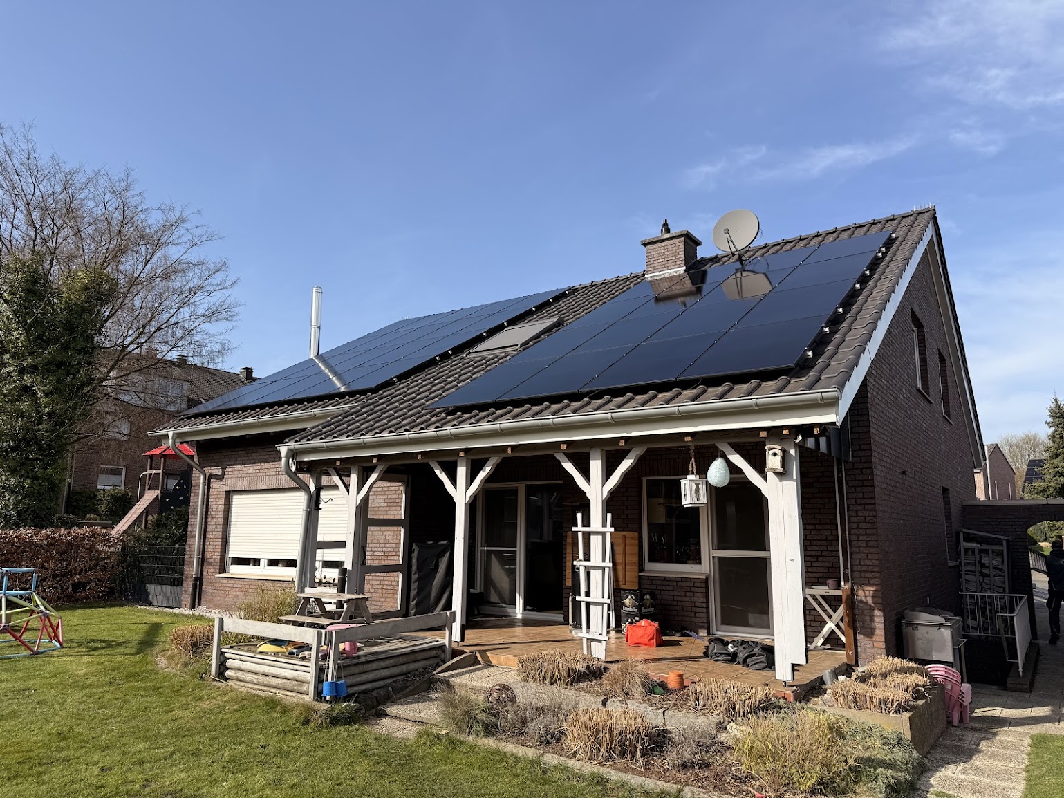 Aufgeständerte Photovoltaikmodule in Reihen auf dem Flachdach eines Mehrfamilienhauses