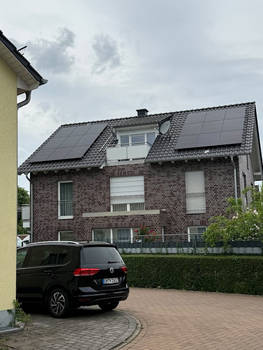 Photovoltaikanlage auf beiden Dachflächen eines Mehrfamilienhauses mit Klinkerfassade